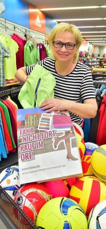 Mit dem Slogan „Fahr nicht fort, kauf im Ort!“ werben Händler der Weißenfelser Innenstadt um Kundschaft. In einer Papiertüte, die hier Andrea Tischer vom Sportfachgeschäft in der Jüdenstraße füllt, können Besucher der Stadt das Motto sprichwörtlich nach Hause tragen.