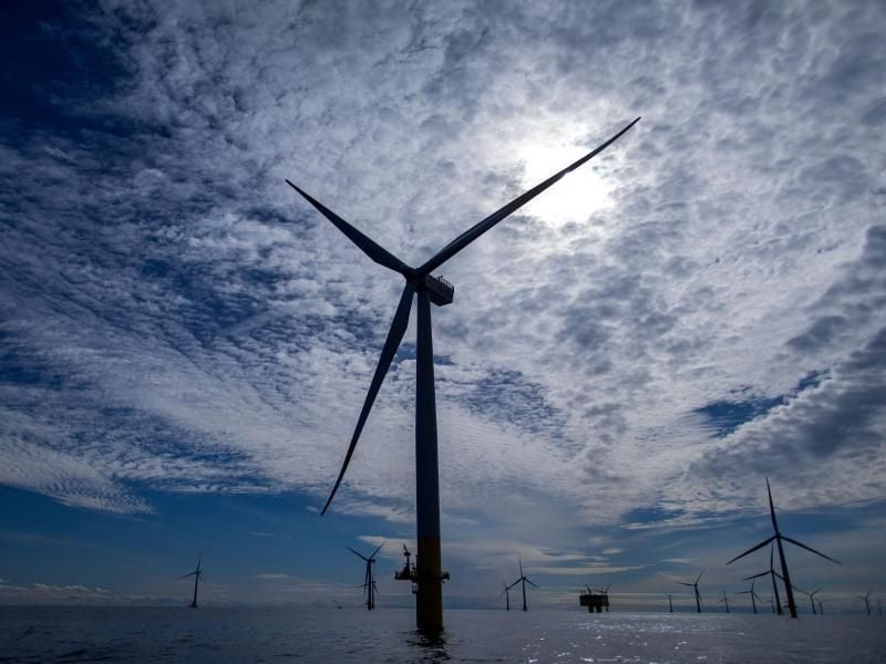 Windräder eines Offshore-Windparks sind im Gegenlicht zu sehen. Foto: Jens Büttner/Archiv