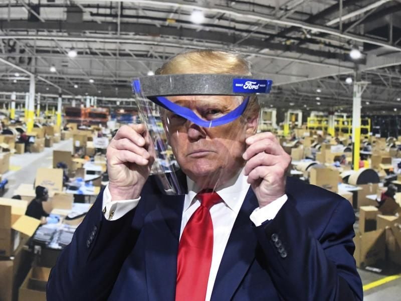 US-Präsident Donald Trump schaut durch ein Gesichtsvisier. Foto: Daniel Mears/Detroit News/AP/dpa