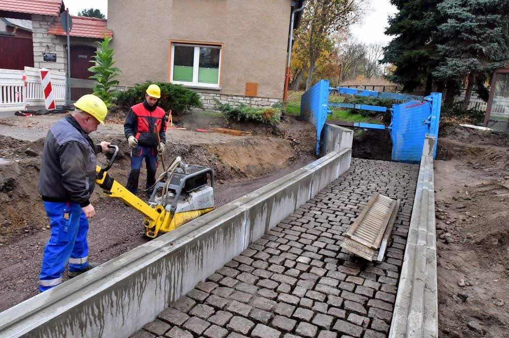 Andreas Scholz (links) und Steffen Pleger sind hier neben dem Bachverlauf beim Verdichten des wieder aufgefüllten Materials.