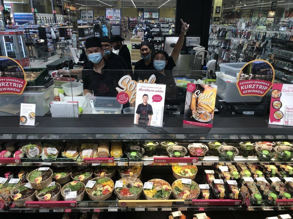 Gut gelaunte Mitarbeiter am Sushi-Stand