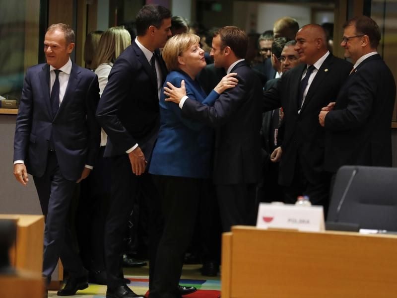 Emmanuel Macron begrüßt Angela Merkel beim EU-Gipfel in Brüssel. Foto: Alastair Grant/AP