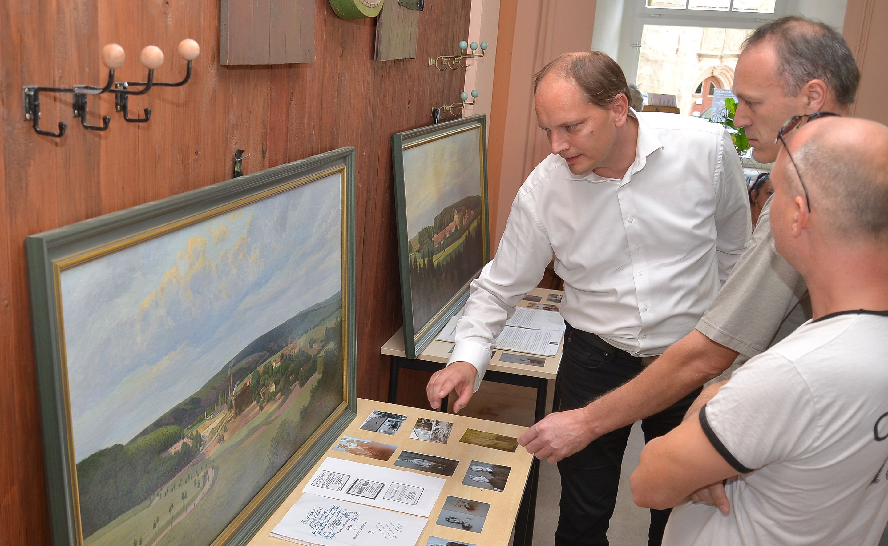 Stephan Müller (li.) aus Köln suchte zum Tag des offenen Denkmals im ehemaligen Rittergut Klosterrode nach Spuren seines Großvaters Maximilian Müller. Er hatte alte Fotos und zwei Gemälde von Neuglück und Klosterrode aus dem Familienbesitz ausgestellt. Hier im Gespräch mit Knut Krüger (re.) und Carsten Pescht.