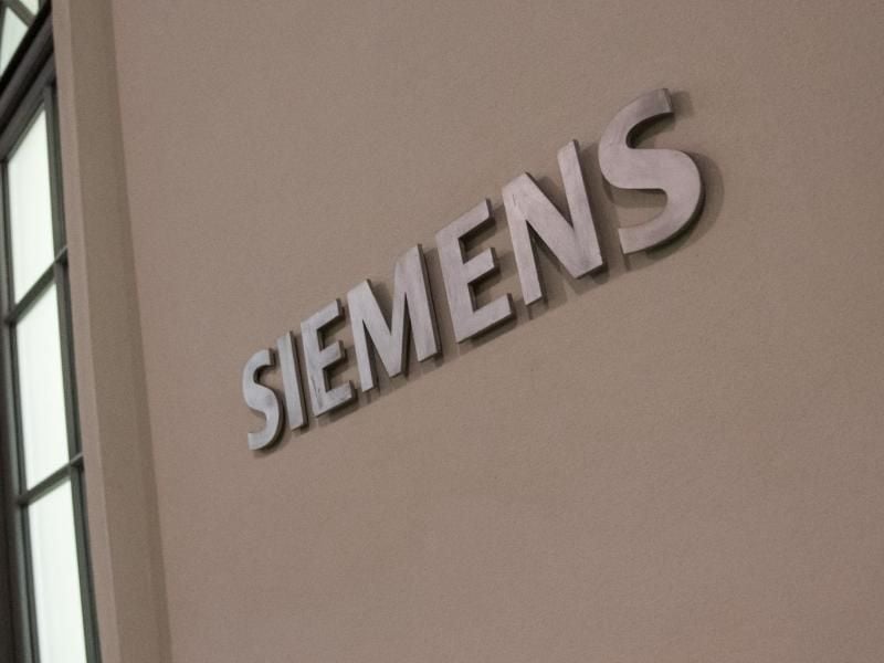 Das Logo der "Siemens" Aktiengesellschaft ist an einem Gebäude zu sehen. Foto: Amelie Geiger/Archivbild