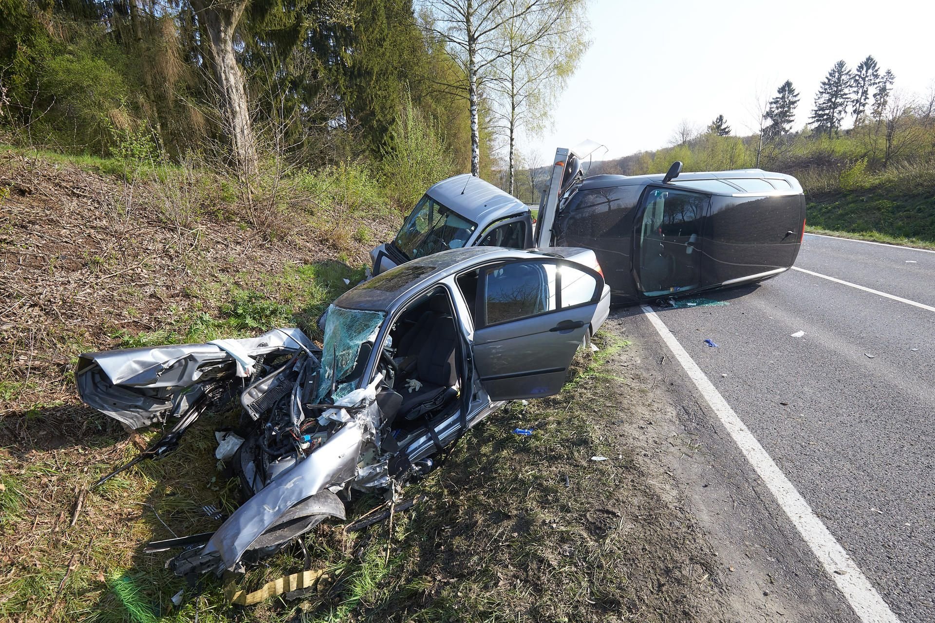 Drei völlig zerstörte Autos liegen nach einem schweren Unfall im Graben neben der L307. Ein Mann kam ums Leben.