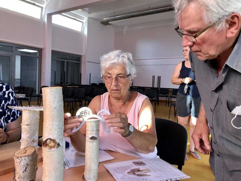 Sigrun Geidel und Horst Schmidt überlegen gemeinsam, wie man am besten Holz und zartes Garn zu einer Dekoration verbinden kann.