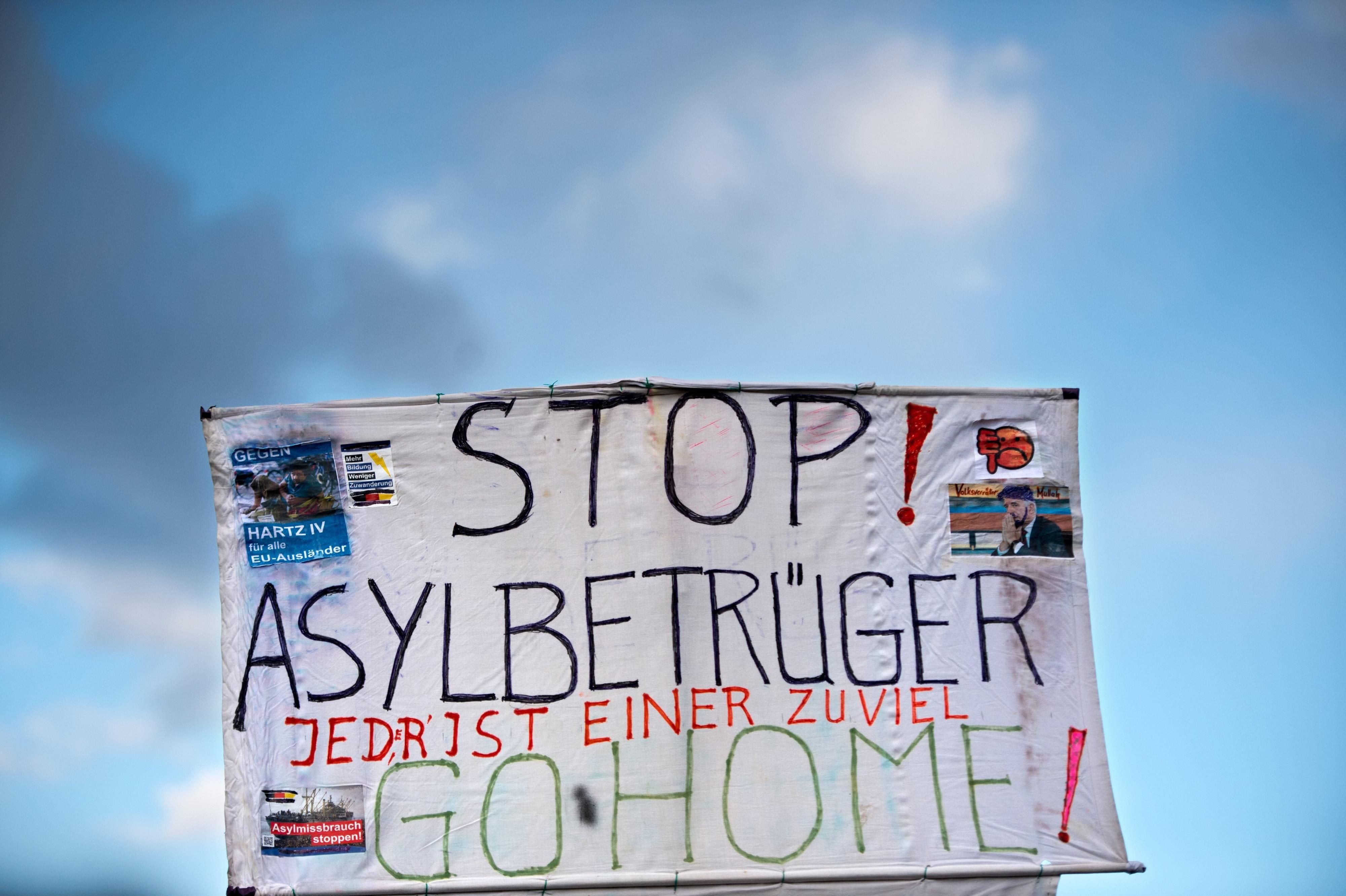 Stereotypen über Flüchtlinge auf einem Plakat im Rahmen einer Pegida-Demo in Dresden.