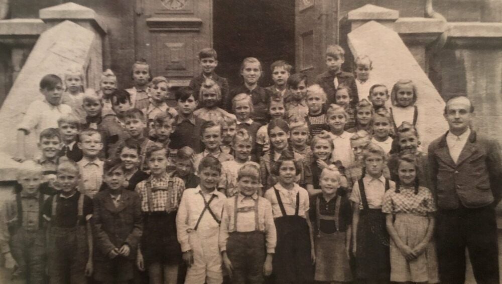 Klassenfoto mit Lehrer Klinger vor dem Eingang der Bergschule, 1949.