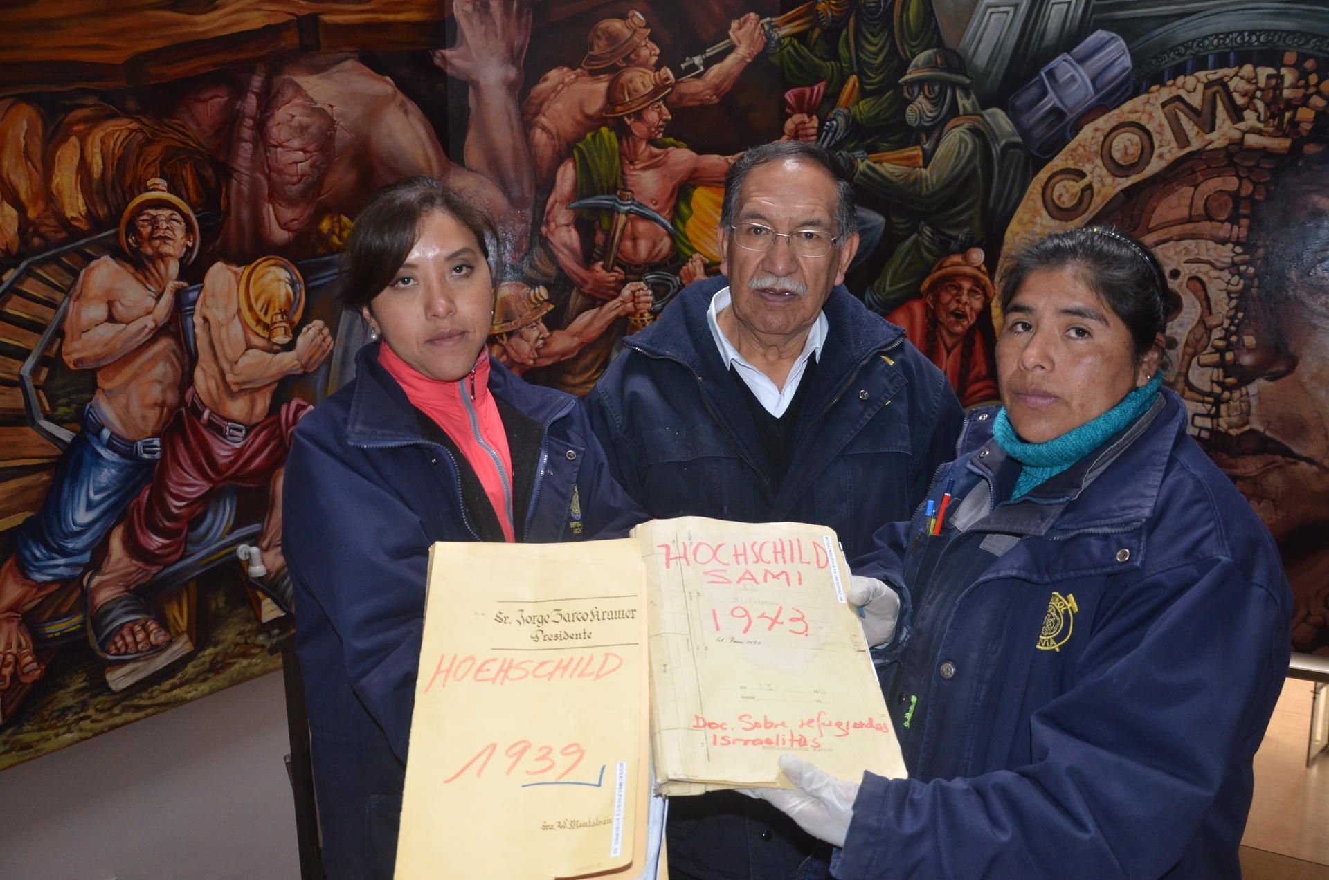 Der Direktor des bolivianischen Minenarchivs Edgar Ramírez (m.) zeigt zwei Akten zur Judenrettung aus dem Archiv.