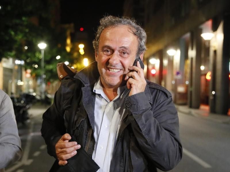 Michel Platini telefoniert nach seiner Entlassung aus dem Gewahrsam der Polizei. Foto: Francois Mori/AP