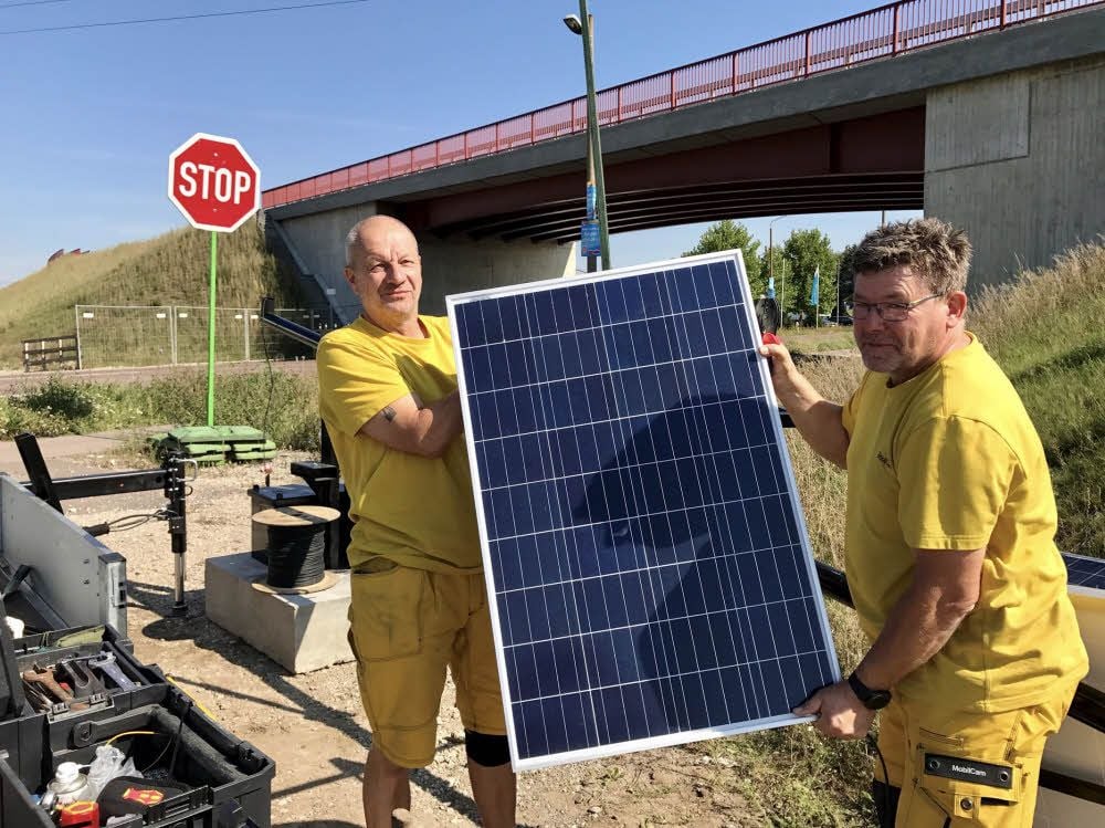 Andreas Hillscher (links) und Heiko Beßler installieren an der neuen Brücke an der Berliner Straße eine solarbetriebene Überwachungskamera.