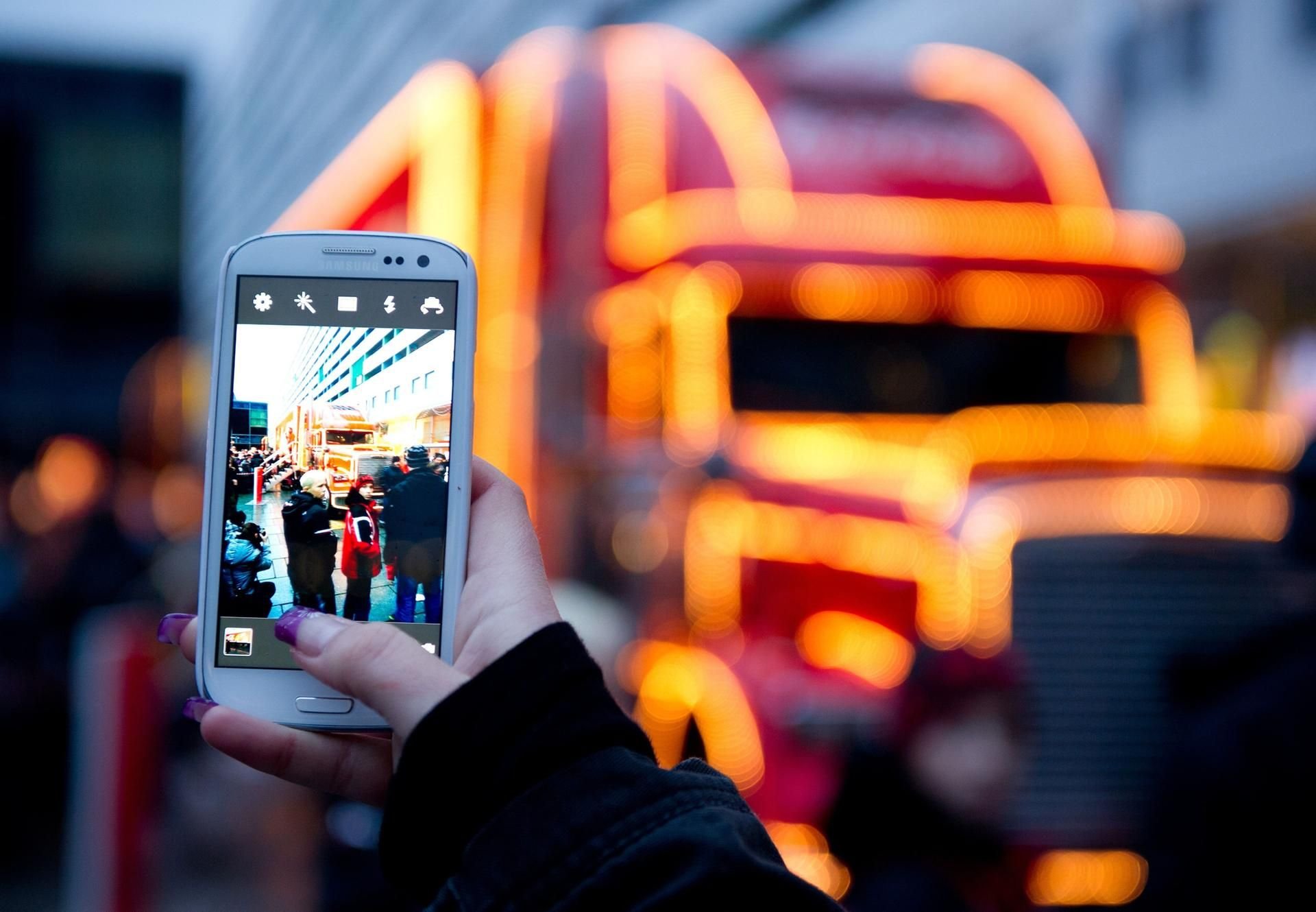 Eine Frau fotografiert den Coca-Cola Weihnachtstruck.
