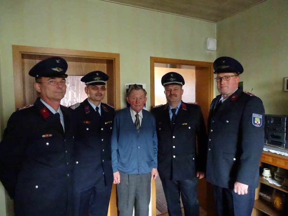 Sie nehmen den Jubilar Heinz Pötzsch in ihre Mitte: Stadtteilwehrleiter Michael Post, Stadtwehrleiter Hans-Peter Schaefer, Bereichsleiter Marco Kralisch und Ortsteilbeiratsvorsitzender Mirko Wolter (von links).