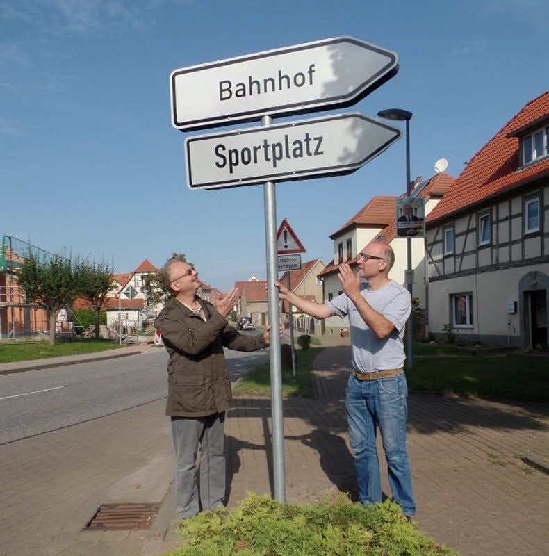 Eisenbahnfreunde der IG Unstrutbahn am von ihnen initiierten Hinweis zum Bahnhof Donndorf bei Artern. Dort hat sich eine Bio-Mosterei etabliert.