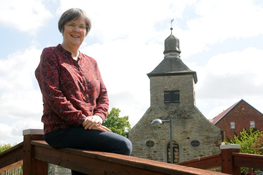 Pfarrerin Anne-Christina Wegner, hier vor der Tröbsdorfer Dorfkirche, ist mit der Region eng verbunden.