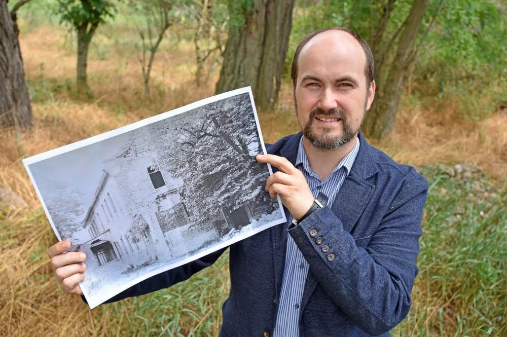 Benny Berger zeigt ein historisches Bild des Hofes.