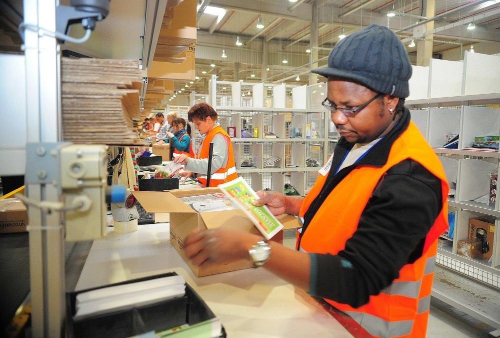 In einer Reihe stehen die Mitarbeiter und füllen die Pakete.