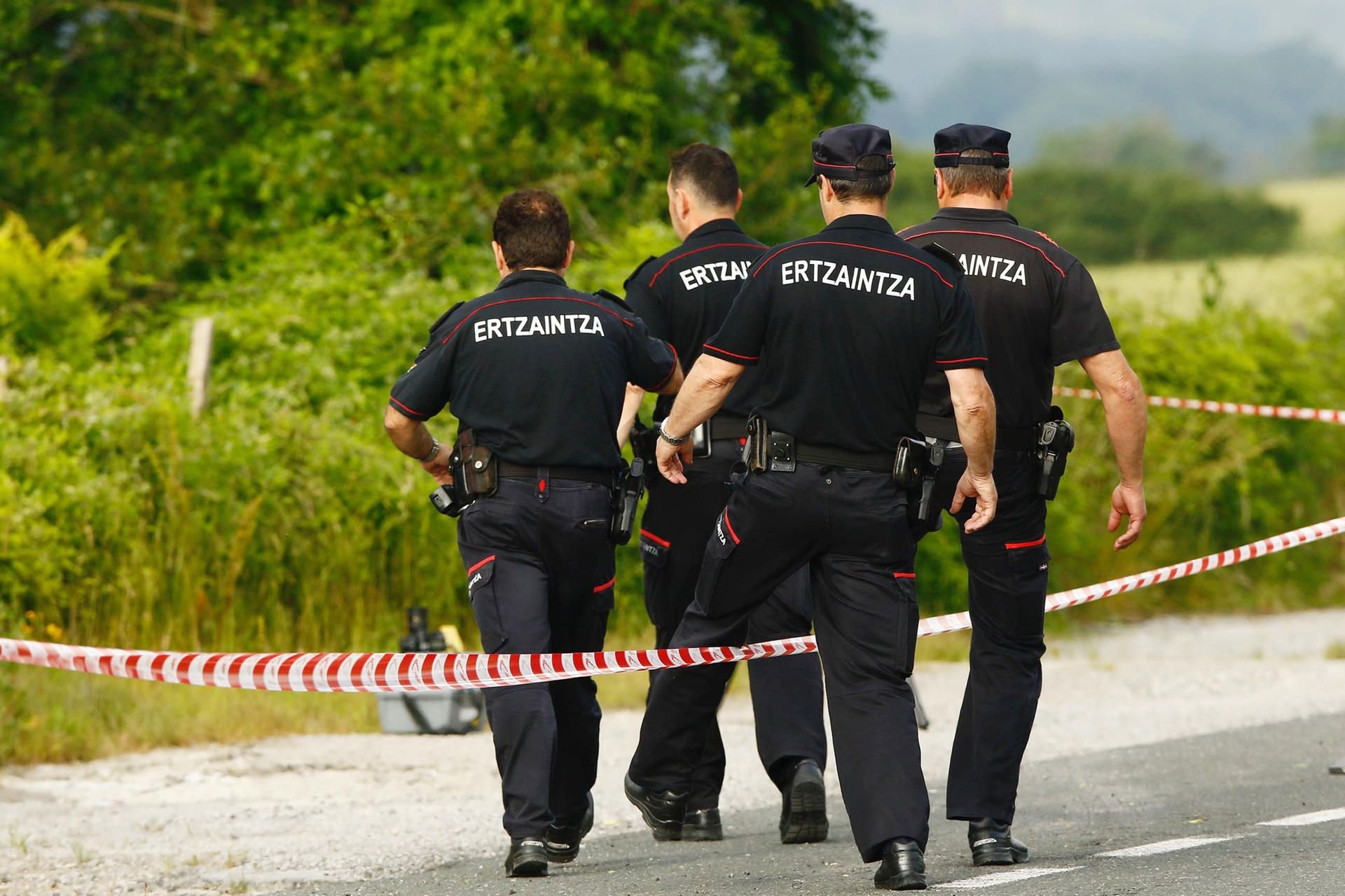 Spanische Polizisten steigen am Fundort von Sophias Leiche, nahe der Autobahn bei Asparrena, über eine Absperrung.