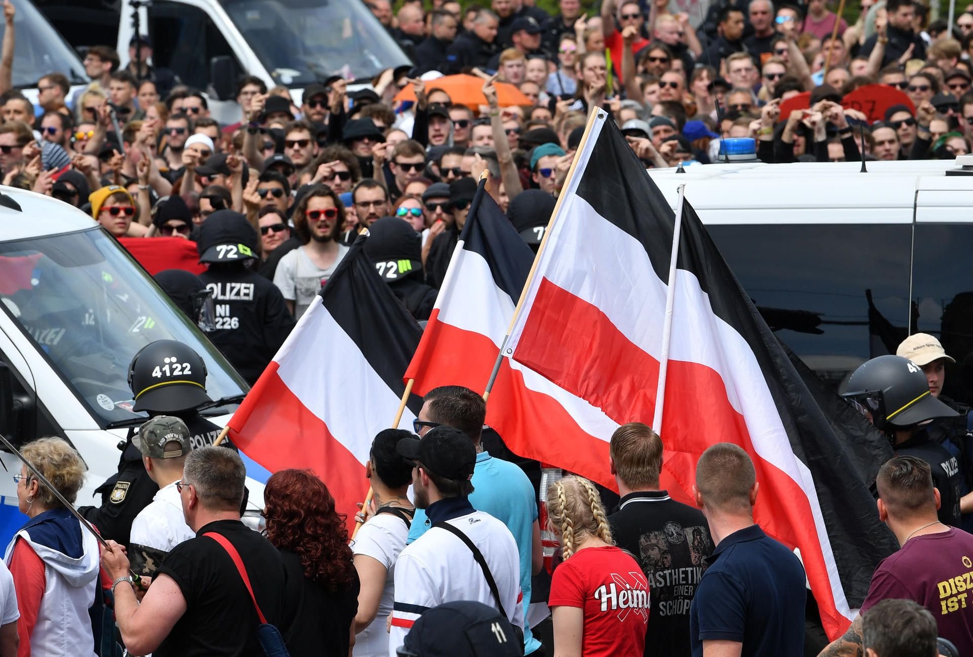 Teilnehmer einer Demonstration der rechtsextremen NPD-Nachwuchsorganisation Junge Nationaldemokraten ziehen unter dem Motto "Tag der deutschen Zukunft" durch Chemnitz an einer Gegenkundgebung (hinten) vorüber.