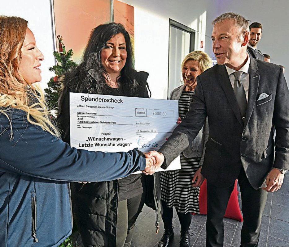 7000-Euro-Scheck an den ASB für das Wünschemobil.