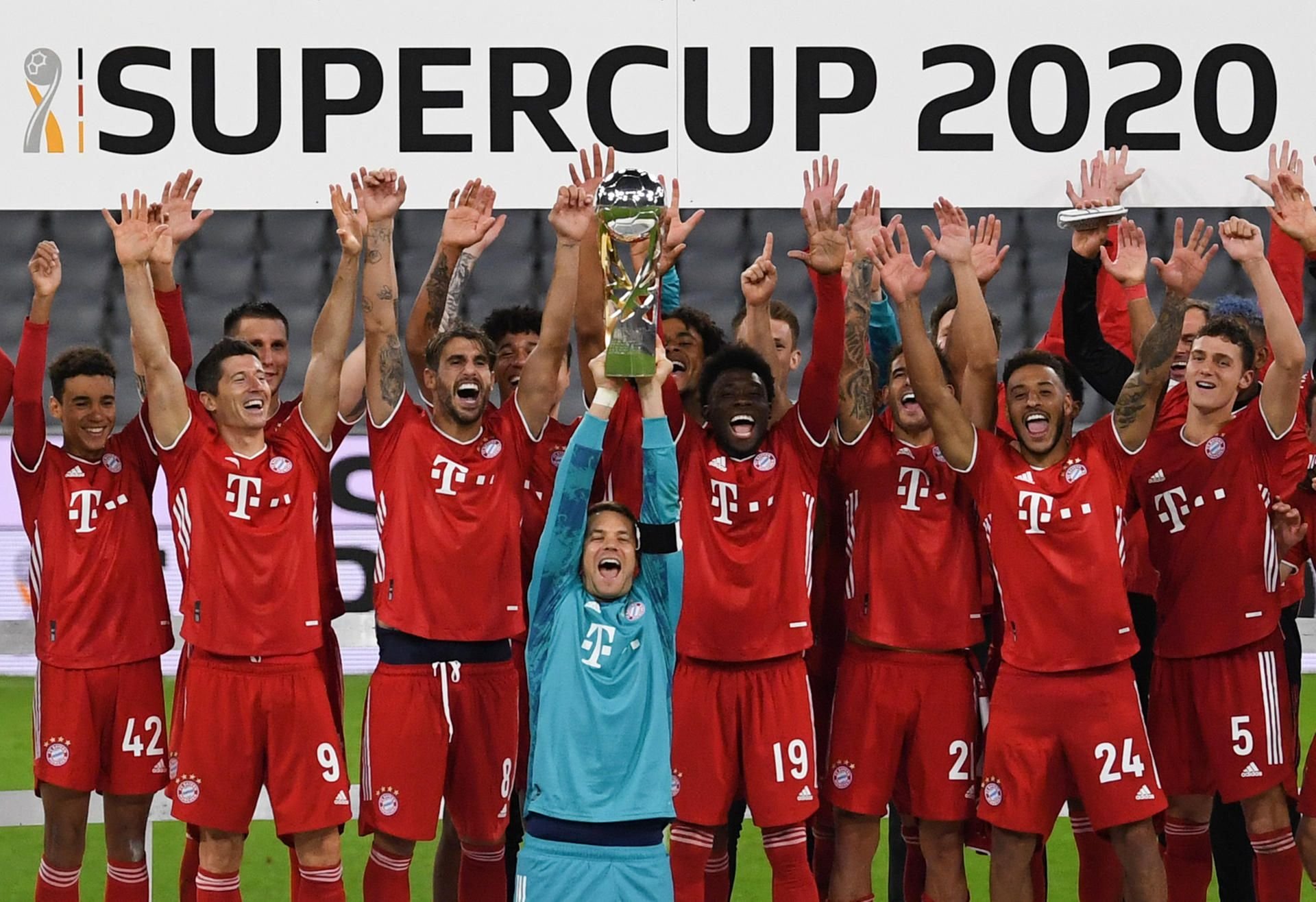 Torwart Manuel Neuer von München hält nach dem Sieg gegen Dortmund die DFB Supercup Trophäe hoch während die Mannschaft den Sieg feiert.