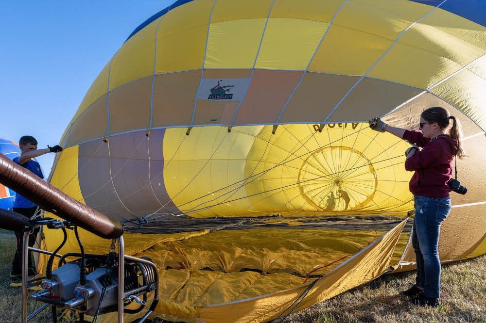 Leon und Sarah halten den Ballon auf, während Luft hineingeblasen wird.