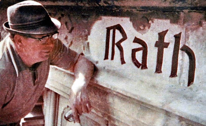 Ein Bild aus den 1970er Jahren zeigt Reinhard Steinbachs Vater bei Restaurierungsarbeiten an der Inschrift des Bernburger Rathauses.