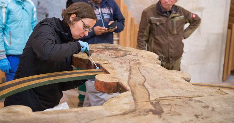 Bevor das Triumphkreuz hinaufgezogen wird, erledigt Restauratorin Stephanie Exner letzte Arbeiten an dem Kunstwerk.