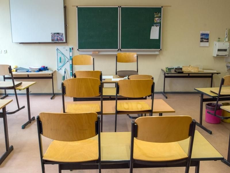 Blick in einen leeren Klassenraum, wo die Stühle auf den Bänken stehen. Foto: Patrick Pleul/Archiv