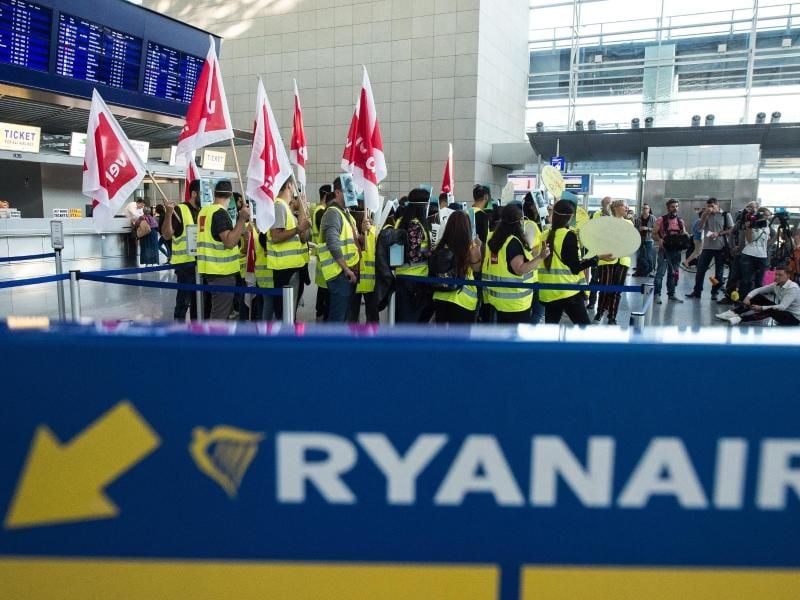 Mitarbeiter von Ryanair haben sich zu einem Warnstreik vor dem Check-in Schalter in Frankfurt versammelt. Foto: Silas Stein