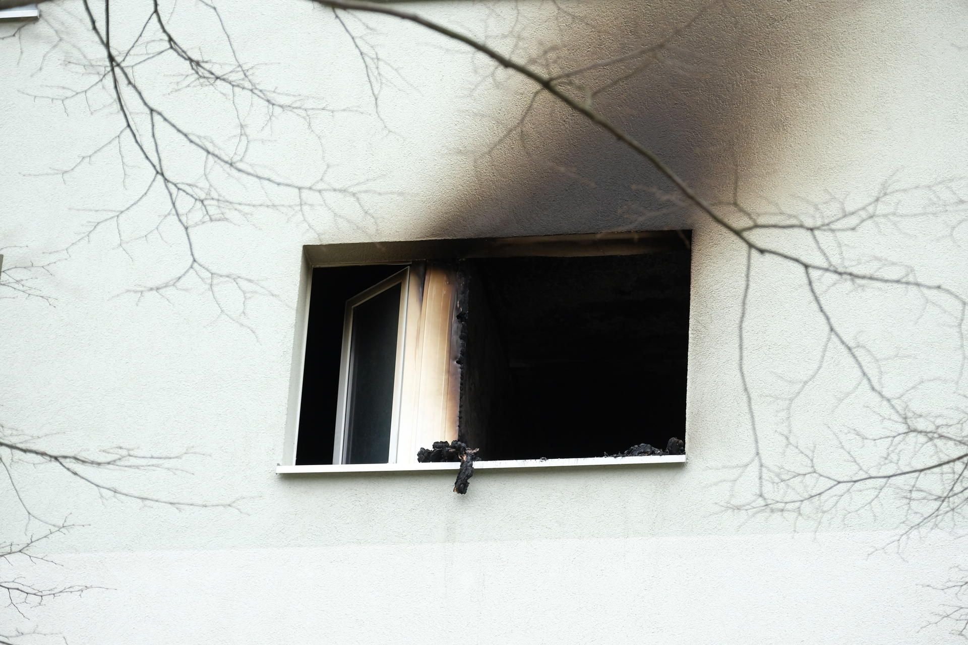 Spuren eines Brandes sind an einem Fenster und an der Fassade eines Mehrfamilienhauses n Grimma zu sehen.