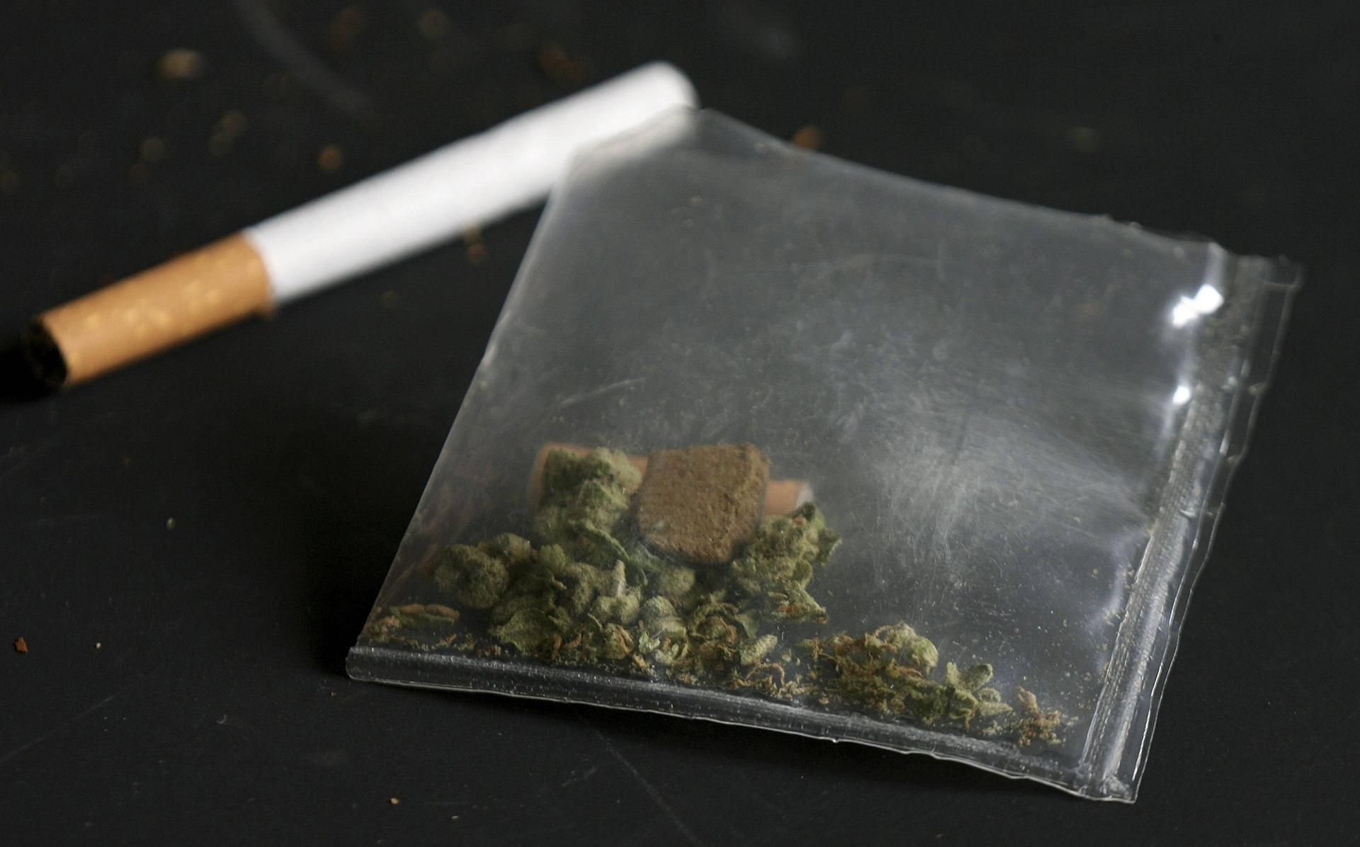 Ein Plastiktütchen mit Marihuana liegt neben einer Zigarette.
