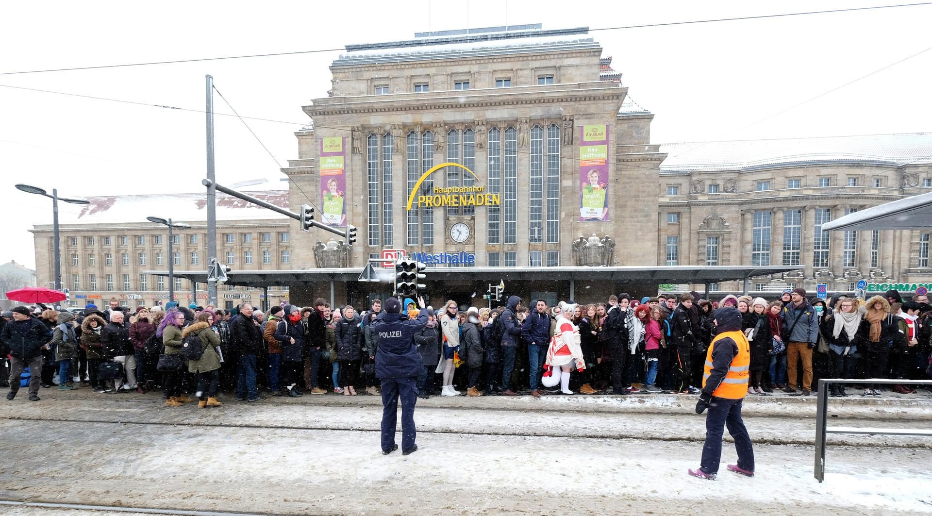 Fahrgäste, darunter Besucher der Buchmesse, stehen dicht gedrängt an einer Haltestelle der Straßenbahn vor dem Leipziger Hauptbahnhof.