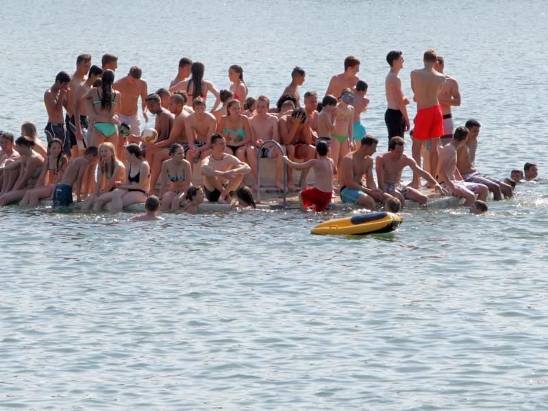 Auf einer kleinen schwimmenden Plattform drängen sich Badegäste. Foto: Fredrik von Erichsen/Archiv