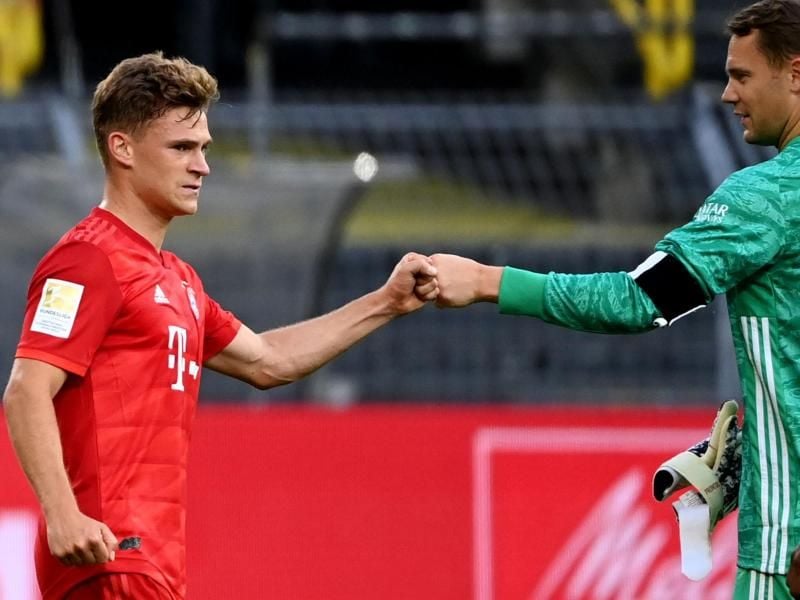 Joshua Kimmich (l) und Torwart Manuel Neuer grüßen sich mit der Faust. Foto: Federico Gambarini/dpa-Pool/dpa
