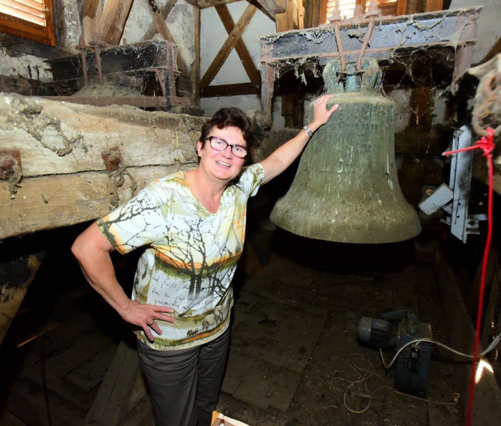 Elke Blücher steht vor einer der Glocken, die sie regelmäßig per Hand läutet.
