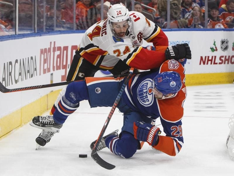 Leon Draisaitl von den Edmonton Oilers wird von Calgarys Travis Hamonic zu Boden gecheckt. Foto: Jason Franson/The Canadian Press/AP