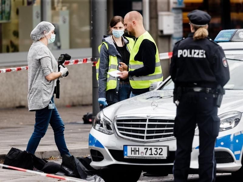 Polizeibeamte sichern in Hamburg Spuren vor einem Supermarkt. Foto: Markus Scholz