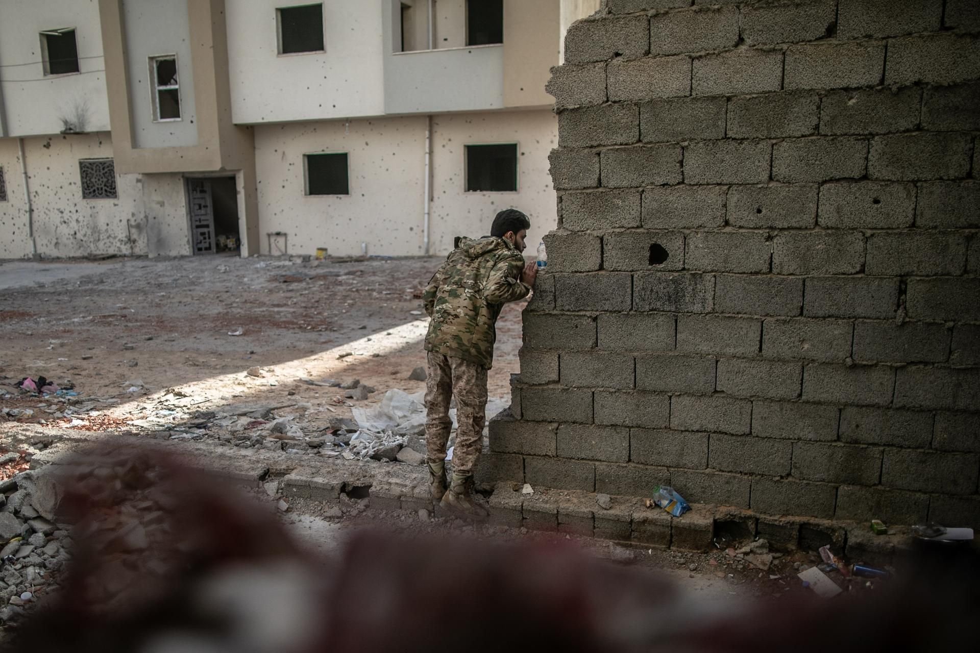 Ein Kämpfer der international anerkannten Regierung schaut während der Zusammenstöße mit den Truppen der Libysch-Nationalen Armee (LNA) um eine Mauer.