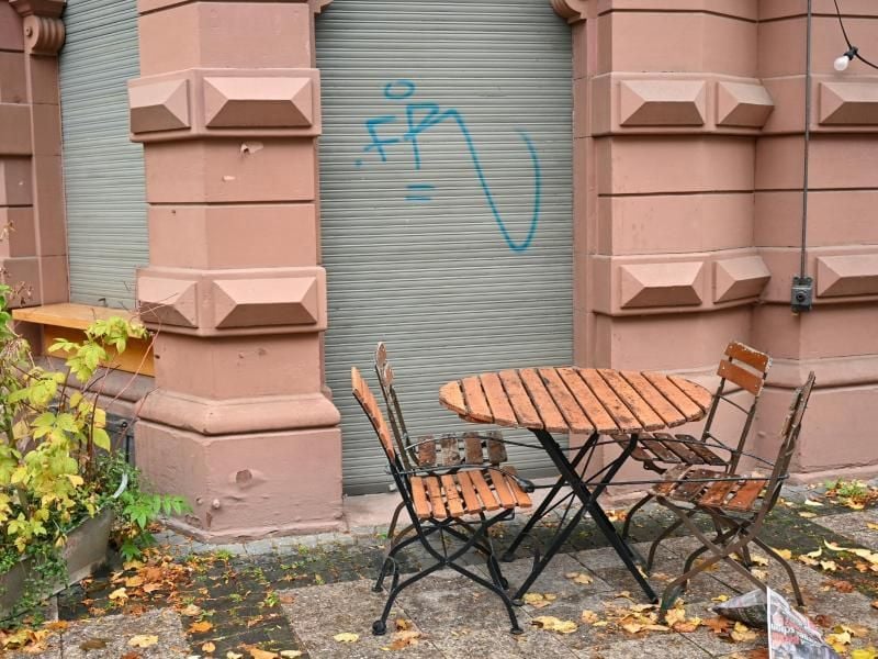 Ein leerer Tisch steht auf der Frankfurter Zeil vor einem geschlossenen Café. Foto: Arne Dedert/dpa/Archivbild