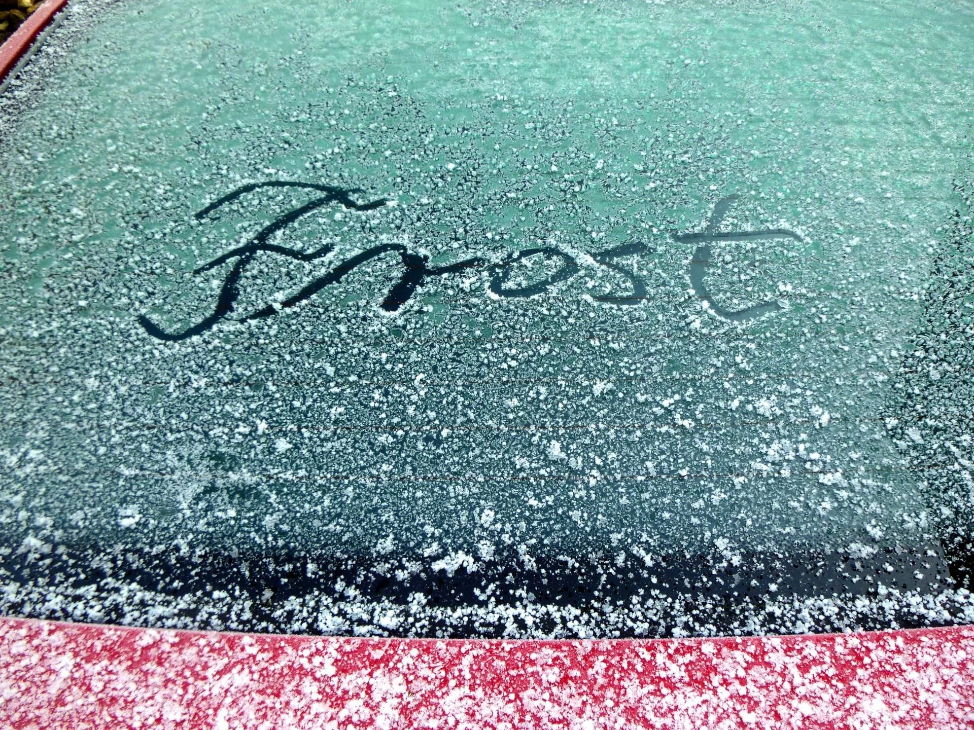 Das Wort Frost wurde in den Rauhreif auf einer Autoscheibe geschrieben.