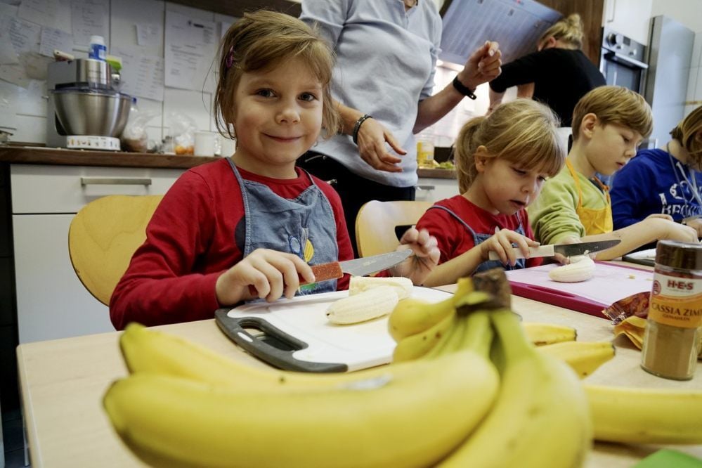 Kulinarischer Adventskalender: Ashley, Anna und Leon (v.li.) schnippeln Bananen, Birnen und Mandarinen für den Obstsalat.