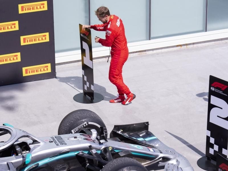 Sebastian Vettel vertauscht in Kanada im Parc Fermé die Nummerntafeln für Platz eins und zwei. Foto: Paul Chiasson/The Canadian Press/AP