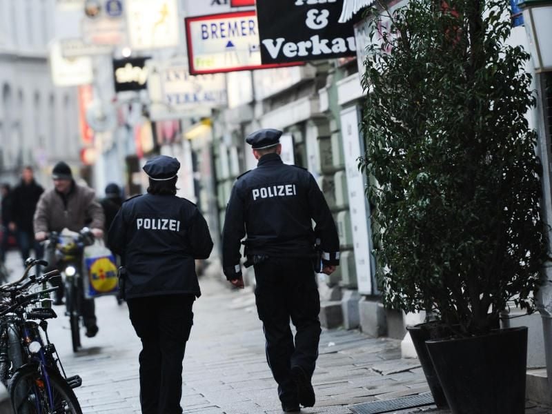 Streifenbeamte der Polizei gehen durch eine Straße am Hansaplatz in Hamburg. Foto: Christian Charisius/dpa/Archivbild