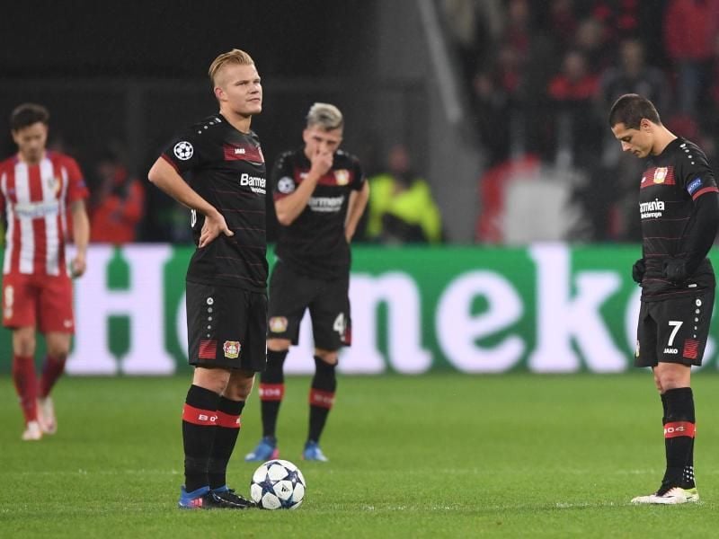 Nach der 2:4-Niederlage gegen Atlético Madrid stehen die Spieler von Bayer Leverkusen im heimischen Stadion geknickt auf dem Spielfeld. Foto: Marius Becker