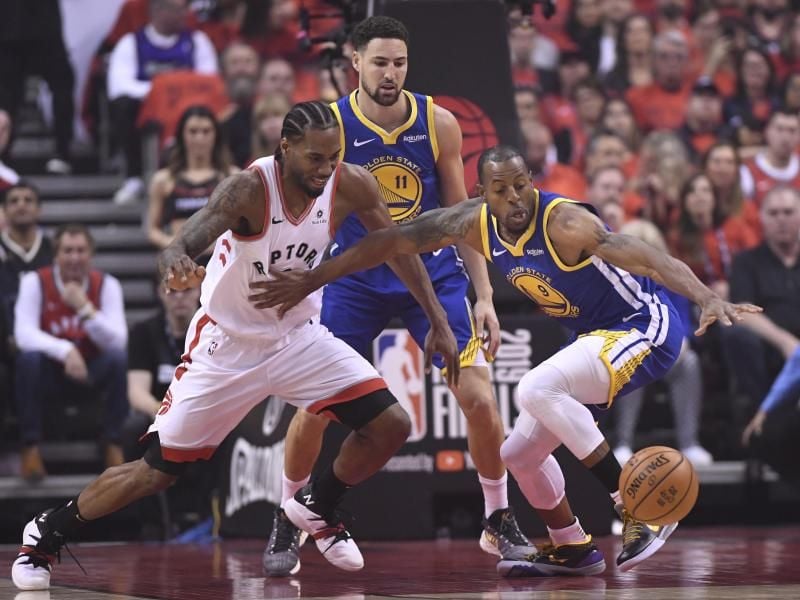 Raptors-Star Kawhi Leonard (l) im Kampf um den Ball mit Andre Iguodala (r) von den Warriors. Foto: Frank Gunn/The Canadian Press