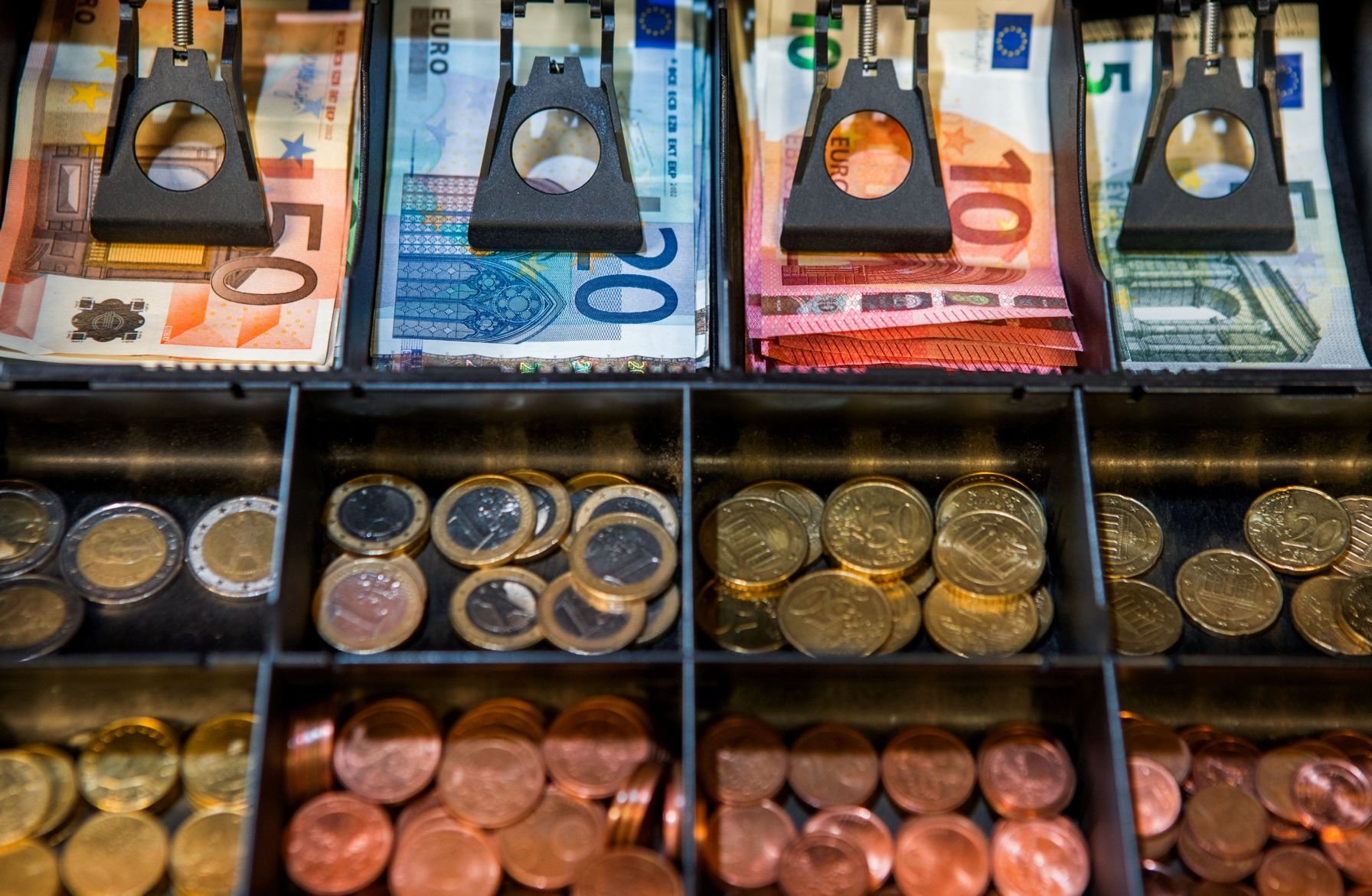 Euro-Scheine und -Münzen liegen im Geldschubfach einer Ladenkasse.