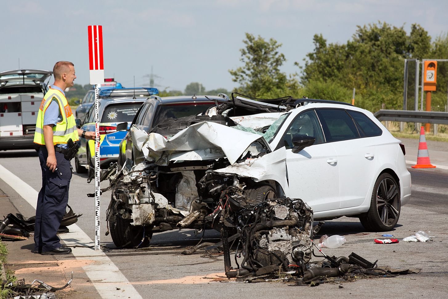 Ein Polizist untersucht einen Wagen nach einem Verkehrsunfall auf der Autobahn 4 bei Burkau.