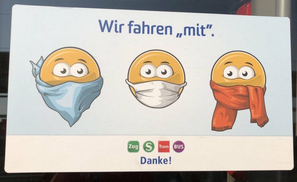 Aufkleber in einer S-Bahn weisen auf die Maskenpflicht hin.
