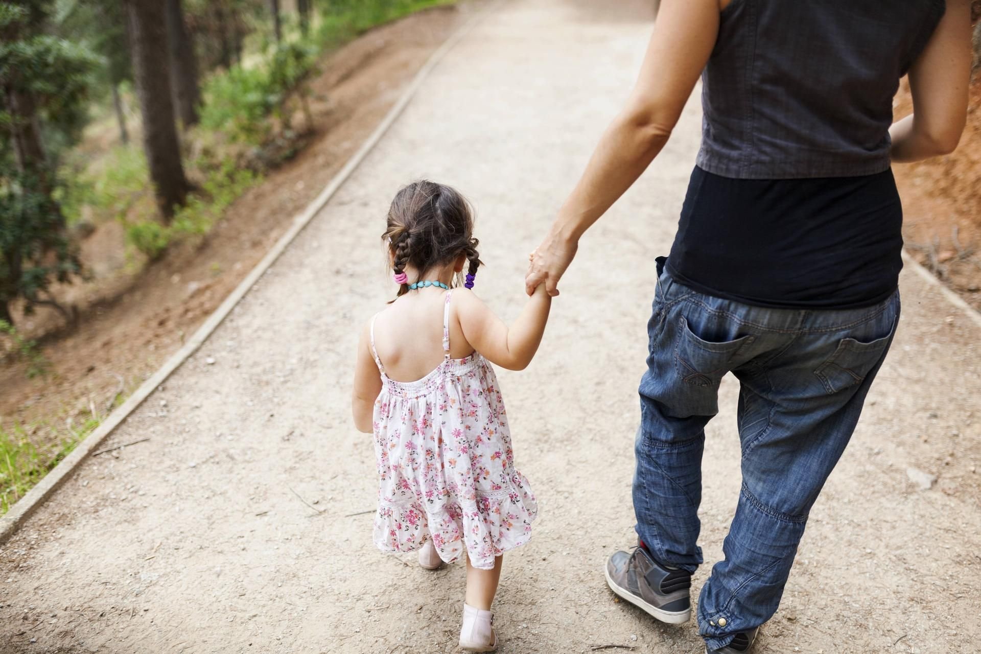 Kleinkind an der Hand seiner Mutter
